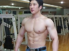 Big muscled dude is topless flexing up his muscles and abs