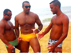 Good looking dudes are topless at the beach showing some abs